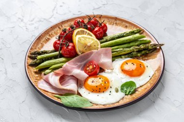 Ketogenik diyet. Keto kahvaltısı. Yağda yumurta, kuşkonmaz, jambon, domates ve salata. Yemek tarifi geçmişi. Kapat..