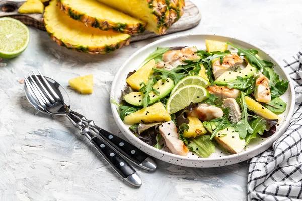 Grilled chicken breast, pineapple, avocado, green rocket salad, lime and olive oil. selection of healthy food.