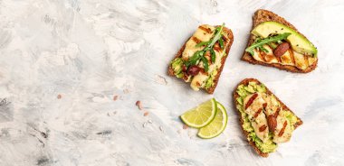 Izgara Halloumi peyniri ve beyaz arka plan manzaralı avokado guacamole dilimleri. Sağlıklı yiyecekler. Uzun pankart biçimi