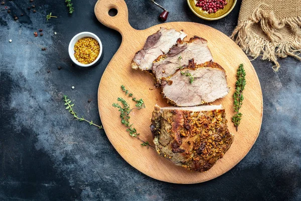 Roasted sliced Christmas ham of turkey. large piece of baked pork with mustard on a cutting board. banner, menu recipe place for text, top view.
