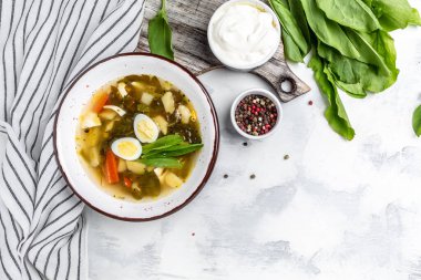 Kızlı ve yumurtalı geleneksel çorba, beyaz arka planda patates. Yeşil borç, pankart, metin için menü tarifi yeri, üst görünüm.