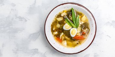 Kasede yeşil otlu krema çorbası. Yumurtalı, patatesli, havuçlu, maydanozlu kuş çorbası. Uzun afiş biçimi. en üstteki görünüm,