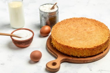 Beyaz ahşap bir masada malzemeli ev yapımı kek. Fırının arka plan konsepti. Metin için pankart, menü tarifi yeri,