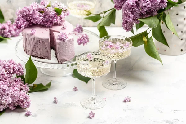 Delicious berry mousse cake, with prosecco, champagne, wine, bouquet of purple blooming lilacs, French cuisine, postcard, background,