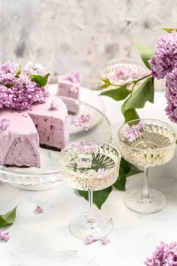 Lezzetli bir Prosecco, şampanya, çilekli kek buketi mor leylaklar, Fransız mutfağı, kartpostal, arka plan. metin için dikey resim yeri.