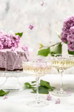 Prosecco, şampanya, şarap ve böğürtlenli turta, bir buket mor zambak, kartpostal, arka plan. metin için dikey resim yeri.
