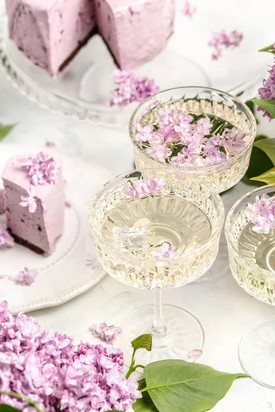 Prosecco, şampanya, şarap ve böğürtlenli turta, bir buket mor zambak, kartpostal, arka plan. metin için dikey resim yeri.