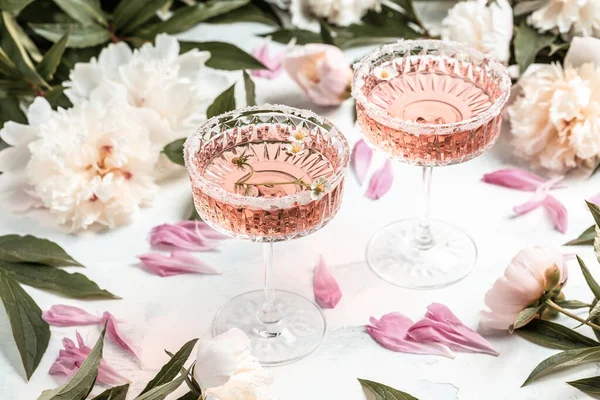 stock image Delicious rose wine in glasses and many peony flowers. Summer celebration, wedding greeting card, invitation concept