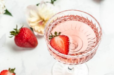 Bir bardak beyaz şarap, taze çilek ve şakayık çiçekleri. Parti için yaz içeceği, şarap dükkanı ya da şarap tatma konsepti.