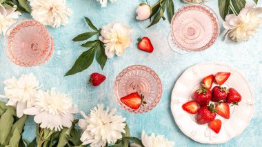 Fıstık çiçekli gül şarabı mavi arka planda tatlı taze çilek, parti için yaz içeceği, şarap dükkanı veya şarap tatma konsepti.