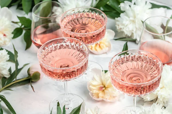 stock image Rose sweet wine in glasses with Peony Flowers on white background, Summer drink for party, wine shop or wine tasting concept.