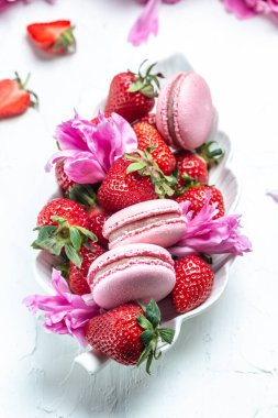 Pink peonies, sweet strawberry and macaron cookies dessert, on a white background. Banner, flyer, beautiful postcard, top view.