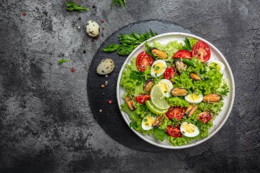 Salad with mussels, quail, egg, conjugate, lime, spinach, lettuce, cherry tomatoes and microgreen. Dietary salad. banner, menu recipe place for text top view.