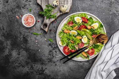 Healthy salad with mussels, quail, egg, conjugate, lime, spinach, lettuce cherry tomatoes and microgreen. Keto lunch diet.