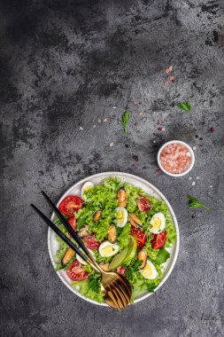 Healthy salad with mussels, quail, egg, conjugate, lime, spinach, lettuce cherry tomatoes and microgreen. Keto lunch diet. place for text, vertical image top view.