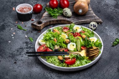 Salad with mussels, quail, egg, conjugate lime, spinach lettuce cherry tomatoes and microgreen. Dietary salad. Food recipe background. Close up.