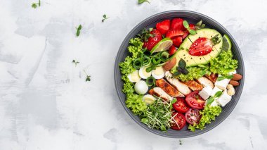 Sağlıklı keto, ketojenik öğle yemeği menüsü ızgara tavuk eti, avokado, feta peyniri, bıldırcın yumurtası, çilek, fındık ve marul. Kızarmış tavuk göğsü, fileto ve taze sebze salatası..