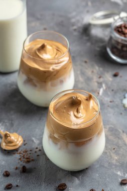 Dalgona kahvesi. Tarifi popüler Kore kahvesi ve köpüklü kahve. Yumuşak bir içecek. İki bardak Kore kahvesi. dikey görüntü. en üstteki görünüm.