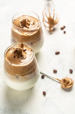 Modayı takip eden Dalgona kahvesi, Kore kahvesi, iki bardakta köpüklü hazır kahve. dikey görüntü. en üstteki görünüm.