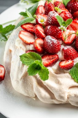 Avustralya usulü Pavlova pastası kremalı krema, taze çilek ve naneli. Yemek tarifi geçmişi. Kapat.,