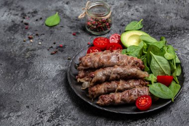 chevapchichi veya Kofta kebabı, domuz pastırması ıspanak, avokado ve kiraz domatesi ile doğranmış et, sağlıklı yağ, kilo vermek için temiz yemek. Keto paleo diyet menüsü, üst görünüm,
