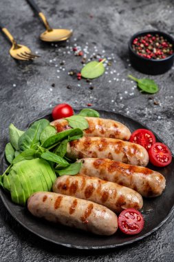 Ispanak, avokado ve vişneli domatesli ızgara Münih Veal Sausages. Ketogenik diyet, dikey görüntü. Üst Manzara. metin için yer.