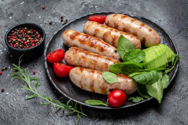 Fried sausages with with spinach, avocado and cherry tomato. hot barbecue dish. Keto paleo diet menu. Food recipe background. Close up. clipart