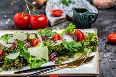 Tavuk ciğeri ve salata yaprakları, parmesan peyniri ve vişneli domates. Lezzetli dengeli gıda konsepti.