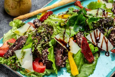 Izgara dana eti ve domatesli taze sebze salatası, marul ve parmesan peyniri. Sağlıklı ve detoks gıda konsepti. Ketojenik diyet.