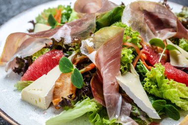 Peynirli peynirli jambonlu jambon salatası ve greyfurt, salata karışımı. Sağlıklı yemek, afiş, menü, metin için tarif yeri, üst görünüm.