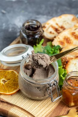 Tahta bir tahtanın üzerinde beyaz ekmek parçalarıyla ördek ciğerinden lezzetli bir ezme. Gurme aperatifler, çeşitli İtalyan aperatifleri bruschetta.