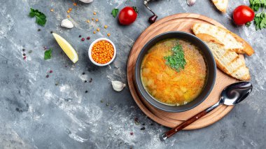 Geleneksel Hint çorbası mercimekleri kasede, baharatlar, gri arka planda otlar. Otantik Hint yemeği. Üst Manzara. Uzun pankart biçimi, üst görünüm.