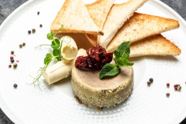 Lezzetli tavuk ciğeri ezmesi, tereyağı, kurutulmuş domates ve tabakta ekmek. Sağlıklı gıda eğilimi.