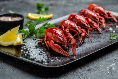 kaynatılmış kerevit ya da limon ve tuzlu kerevit siyah tabakta yemeye hazır. Restoran menüsü, diyet, yemek kitabı tarifi..