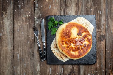 Peynirli, patatesli, otlu, süzme peynirli, biftekli, mantarlı. Ahşap arka planda Ulusal Kafkas yemeği. afiş, menü, metin için tarif yeri, üst görünüm.