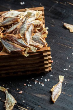 Güneşte kurutulmuş balık, ahşap zeminde tuzlanmış eritilmiş eritilmiş eritilmiş eritilmiş bira için atıştırmalık. Pankart, menü, mesaj için tarif yeri. en üstteki görünüm.