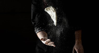 Güzel ve güçlü adamların elleri hamur yoğurur ekmek, makarna ya da pizza yapar. Tozlu un havaya karışıyor. Un bulutunun dondurucu hareketinde un taşıyan şefin elleri.