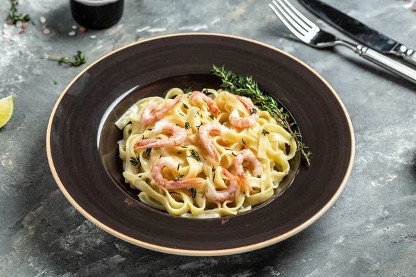 tasty pasta with shrimps, Italian pasta fettuccine with grilled shrimps, bechamel sauce and thyme, banner, menu recipe place for text, top view.