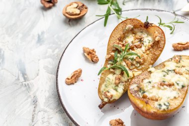 Dorblu, gorgonzola, rokfor peyniri, bal ve cevizle pişirilmiş aperatif armutlar. Sağlıklı yağlar, kilo vermek için temiz yiyecekler..