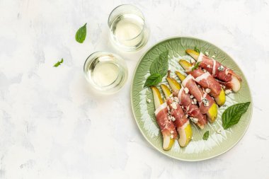 Armut, mavi peynir, jambon ve fesleğenli aperatif. Beyaz şaraplı İtalyan antipasto. afiş, menü, metin için tarif yeri, üst görünüm.
