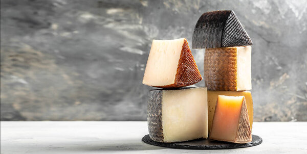 Different sorts of cheese on Light background with copy space. Long banner format.
