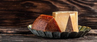 Kırsal ahşap masadaki çeşitli peynir çeşitleri. afiş, menü, metin için tarif yeri.