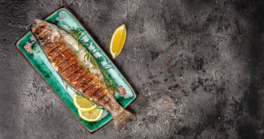 Fırında alabalık tabağı, limon. Lezzetli balıklar öğle yemeği için hazırlanıyor. Sağlıklı beslenme konsepti. afiş, menü, metin için tarif yeri, üst görünüm.