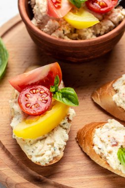 Domatesli bruschetta, krem peynir ve fesleğen. Lezzetli kahvaltı ya da atıştırmalık, temiz yemek, diyet, vejetaryen yemek konsepti. en üstteki görünüm.