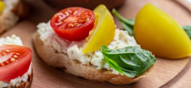 Açık sandviç domates, yumuşak peynir, fesleğen. Lezzetli kahvaltı ya da atıştırmalık, temiz yemek, diyet, vejetaryen yemek konsepti. en üstteki görünüm.