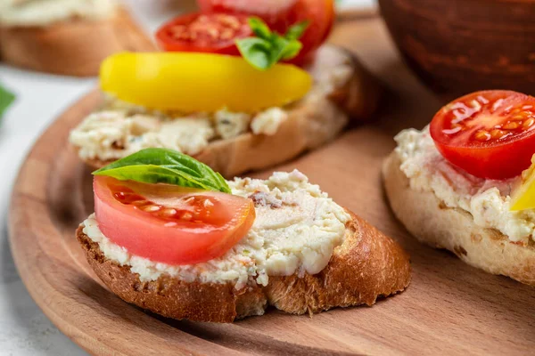 bread toast with tomatoes, cream cheese and basil on a wooden board. Healthy food trend.