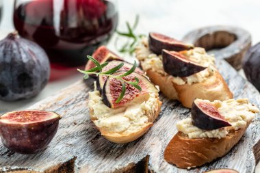 Kanepe ya da kızarmış baget, taze incir, krem peynir ve kırmızı şarapla birlikte crostini. Lezzetli aperatif, ideal aperatif. en üstteki görünüm.
