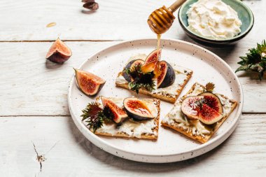Ricotta peynirli crostini, incir ve bal. Beyaz arka plan. İtalyan tarif menüsü.