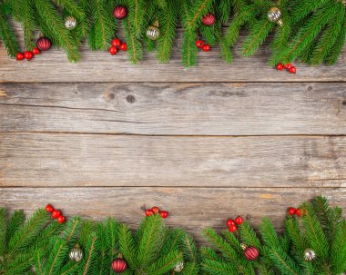 Köknar dalları, kırmızı böğürtlenler ve rustik ahşap yüzeyde mücevherlerle Noel arkaplanı, bayram kutlamaları veya afiş tasarımı için fotokopi alanı olan şenlikli üst görünüm kompozisyonu