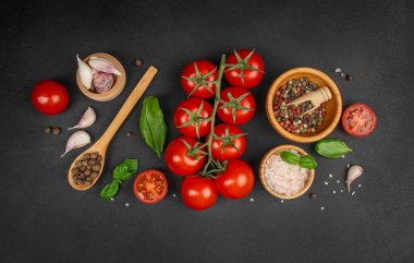 Sarımsak karanfili, fesleğen yaprağı, karabiber ve koyu dokulu arkaplanda tuz karışımı.